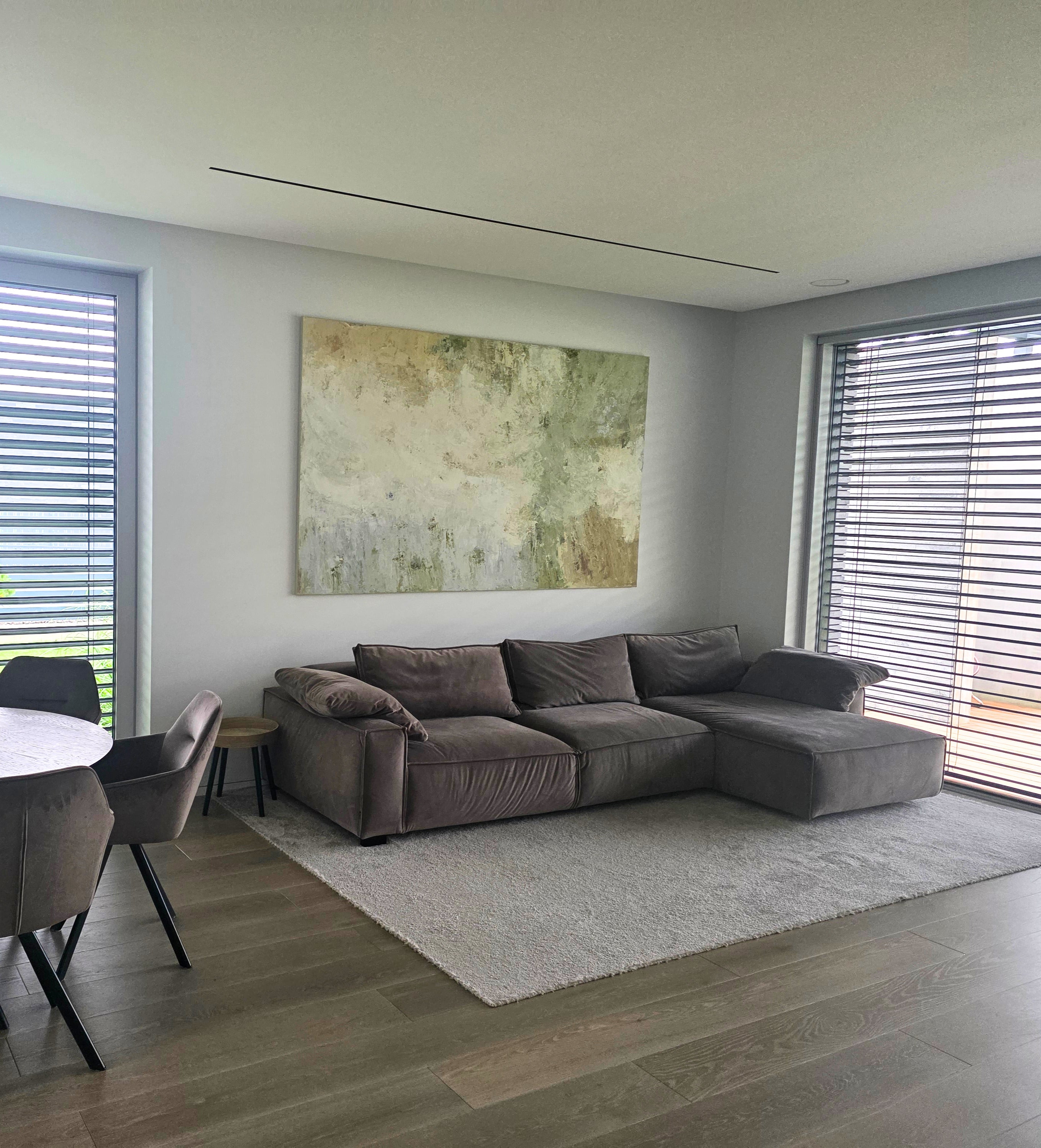 Modern living room with a large sectional sofa, original large-scale abstract painting created by BIRUTE STUDIO.