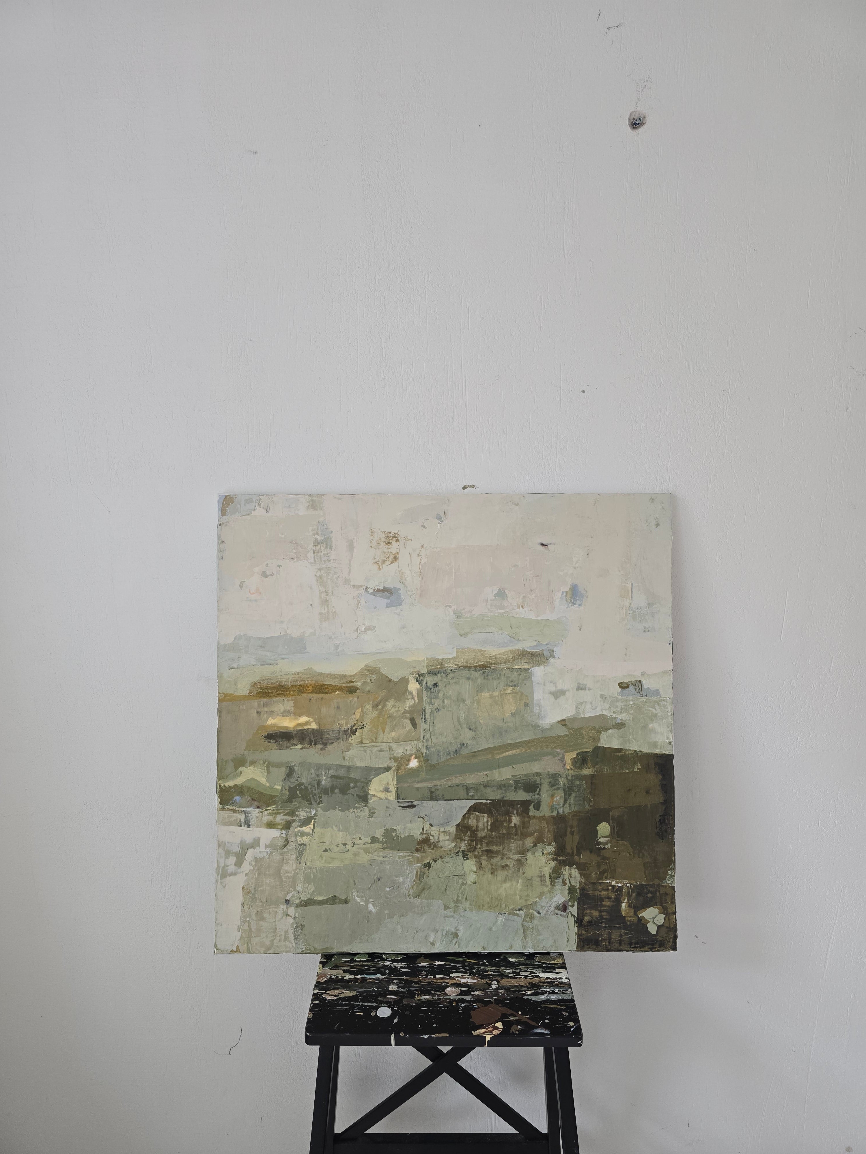 An abstract canvas painting created by Birute Studio in beige, gray, olive green, and brown tones, displayed on a black easel against a plain light gray wall.