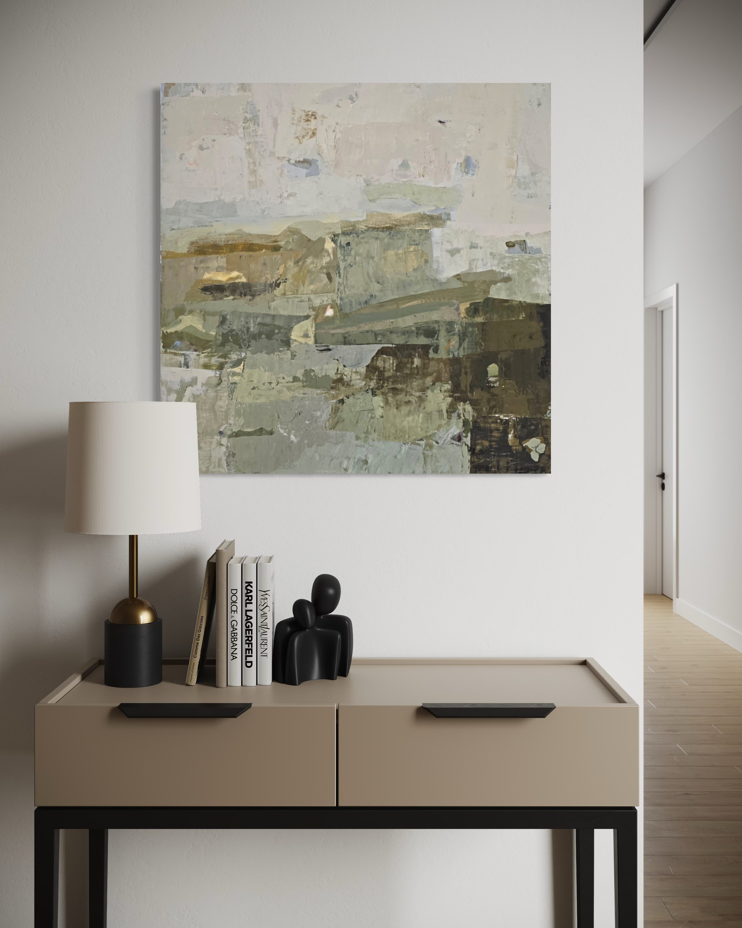 An abstract canvas painting created by Birute Studio in muted beige, gray, and olive tones hangs on a white wall above a console table with a lamp, books, and small black figurines.