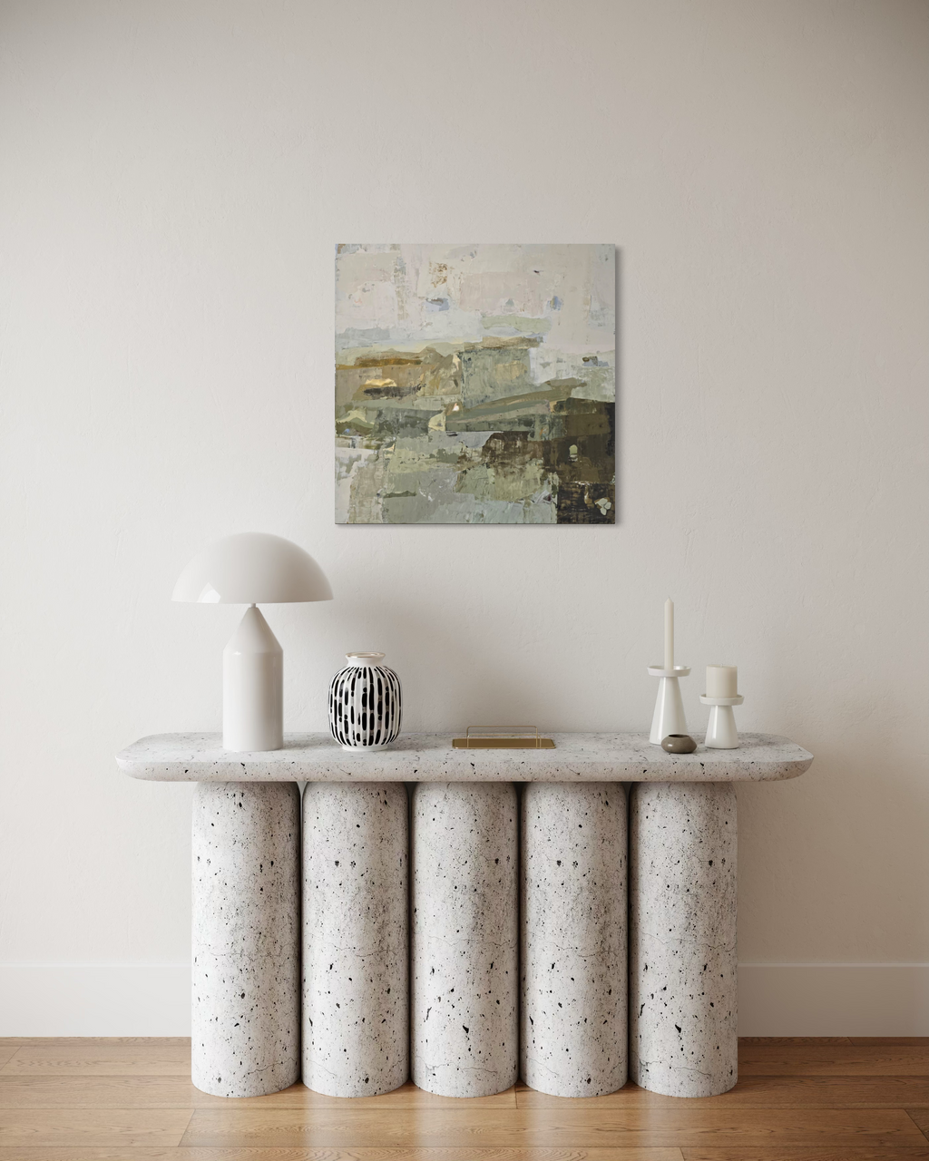 An abstract canvas painting created by Birute Studio in muted earthy tones hangs on a beige wall above a modern console table with cylindrical stone legs and a white mushroom lamp.